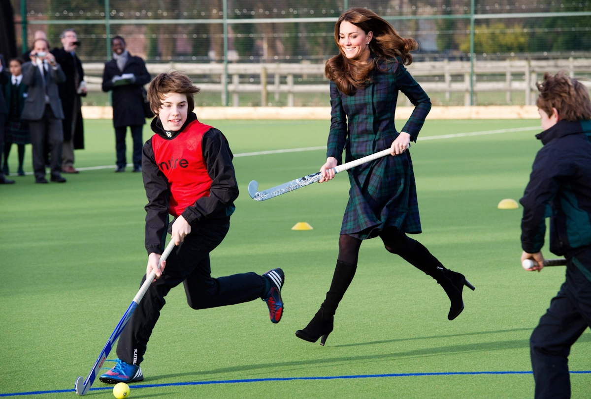 Kate-Middletown-court-avec-ses-talons-hauts-en-jouants-avec-des-enfants-sur-un-terrain-vert.webp