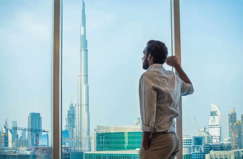 businessman-gazing-through-window-with-city-view-2022-03-07-23-57-36-utc-scaled-1-1.webp